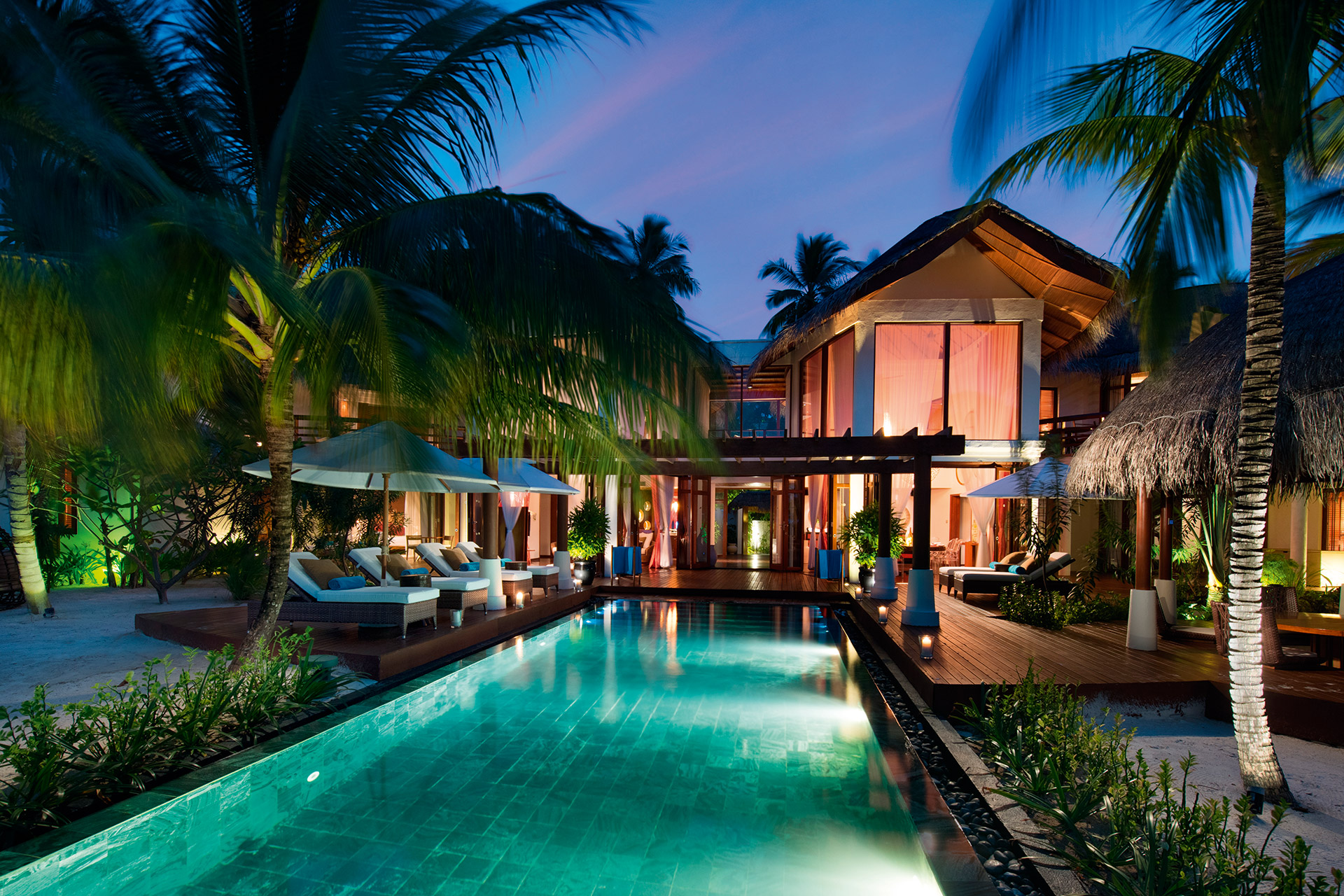 Langer Swimmingpool vor Villa bei Nacht