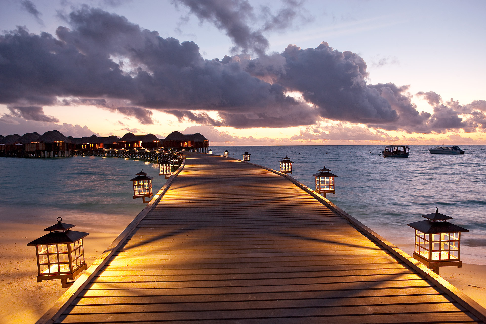 Nächtlich beleuchteter Holzsteg zu Wasservillen