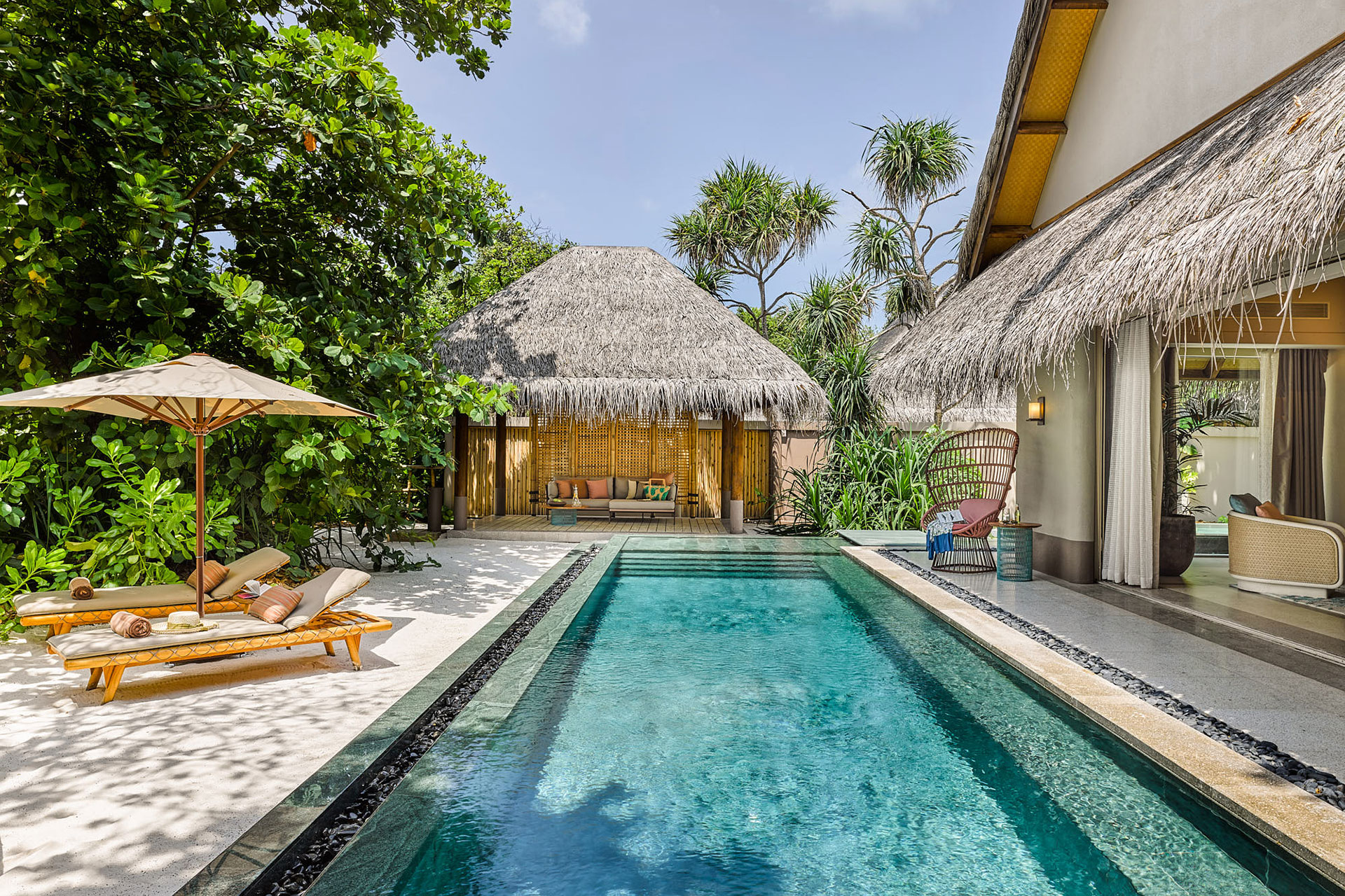 Sonnenliegen vor Pool einer Strandvilla