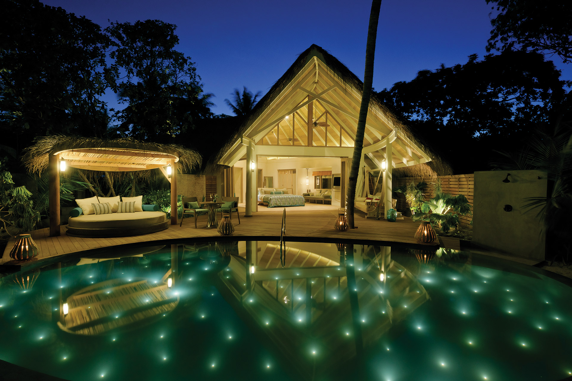 Beleuchteter Pool und Villa bei Nacht