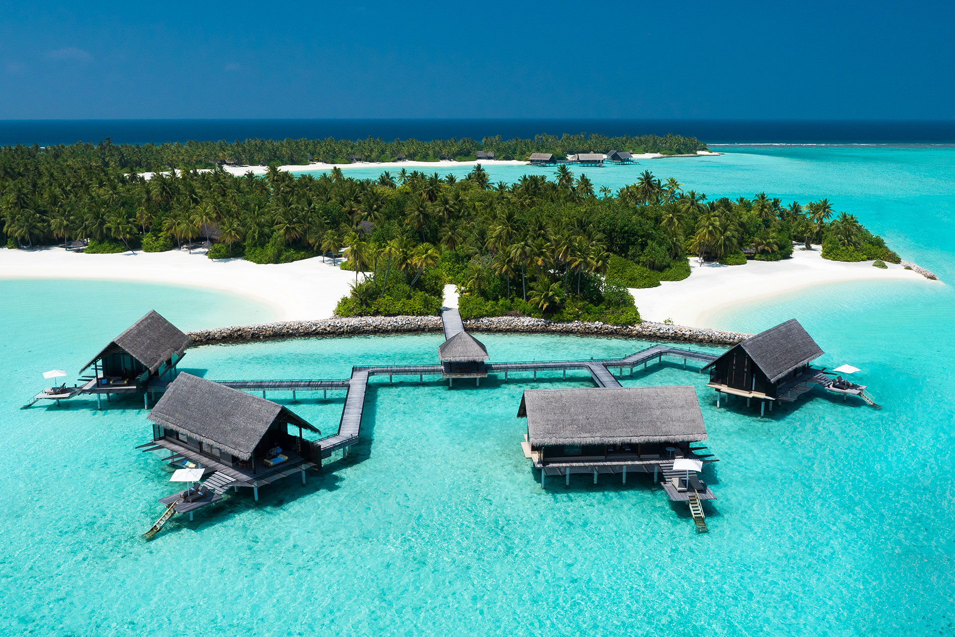 Vier Wasservillen vor tropischer Insel