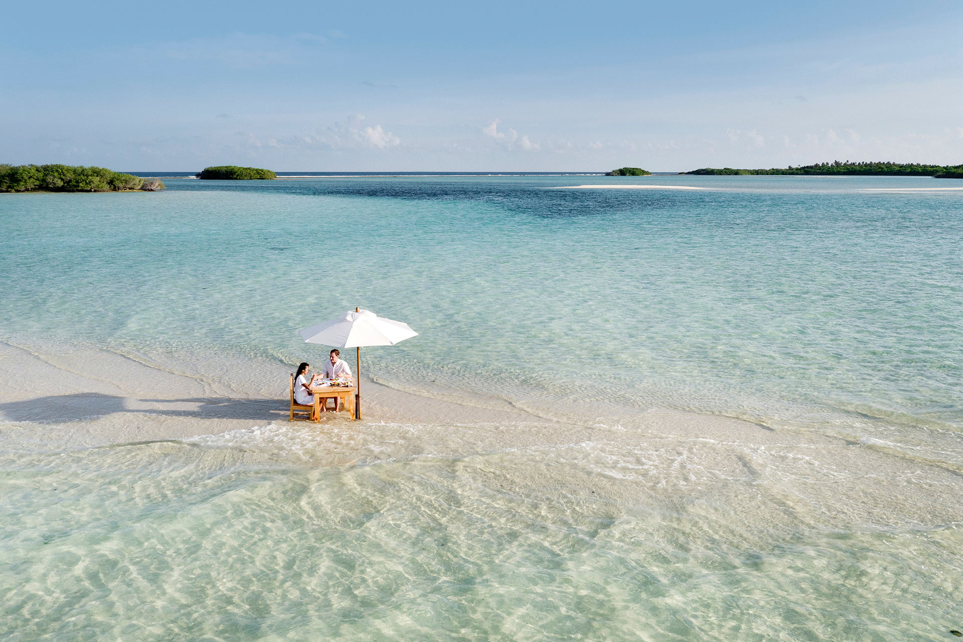 Paar sitzt am Strand beim Essen
