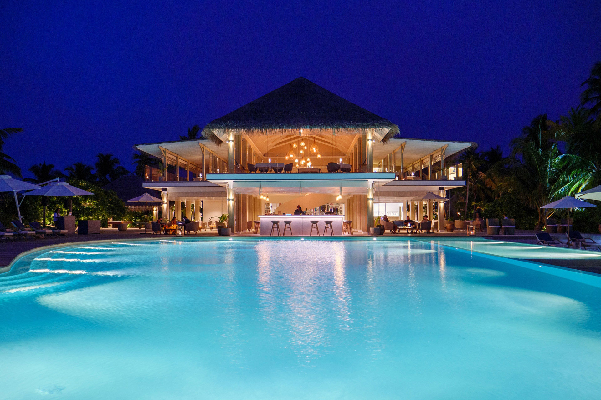 Grosser Pool mit Restaurant bei Nacht